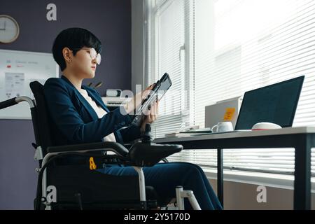 Businesswoman With Disability Working On Tablet PC Stock Photo