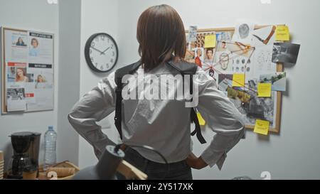 Back view of a woman analyzing a crime investigation board in a police department office. Stock Photo