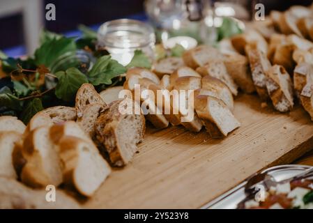Sliced bread and yeast plait on a buffet table with a rustic setup Stock Photo