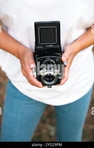 A woman's hands holding an analog medium format camera. Stock Photo
