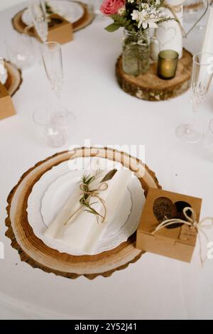 Rustic table setting with wood slice charger and champagne flutes Stock Photo