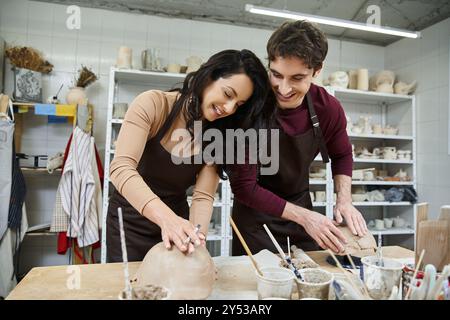 A joyful couple shares creative moments while shaping clay. Stock Photo