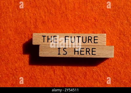 The future is here message written on wooden blocks on orange felt background. Conceptual the future is here symbol. Copy space. Stock Photo