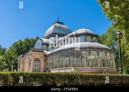 Crystal Palace at Parque del Retiro in Madrid. A large glass building with a dome on top. The building is surrounded by trees and has a lot of people Stock Photo