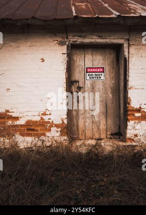 danger sign on abandoned building in woods Stock Photo