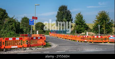 roadworks to repair, maintain or improve a road surface marked by red and white barriers to prevent accidents. Stock Photo