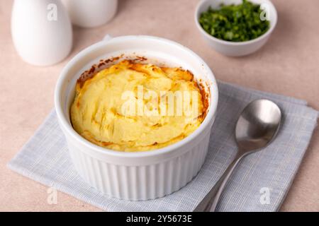 Shepherd's pie in a portioned white baking dish. Homemade traditional casserole (gratin) with minced meat and mashed potatoes. Selective focus, close- Stock Photo