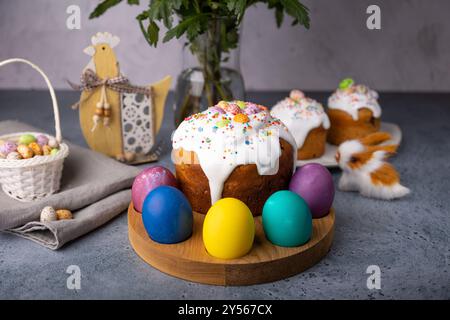Easter kulich with candied fruits in white glaze with colorful sprinkles and painted eggs. Traditional Easter pastry. Easter holiday. Close-up, select Stock Photo