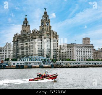 Merseyside Fire and Rescue rigid inflatable speed boat, River Mersey with city landmark Royal Liver building, Pier Head, Liverpool, England, UK Stock Photo