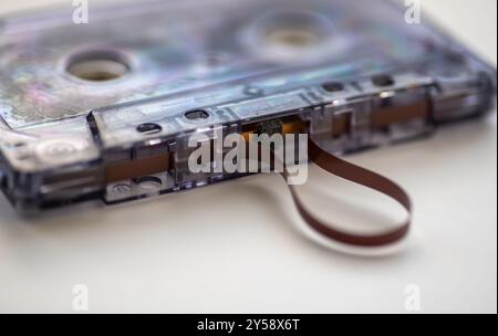 Close up of a music cassette tape with the tape coming out, isolated in a white background. Stock Photo