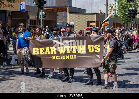 Bearded men holding Bear with Us Helsinki banner at Helsinki Pride 2024 parade on Mannerheimintie in Helsinki, Finland Stock Photo