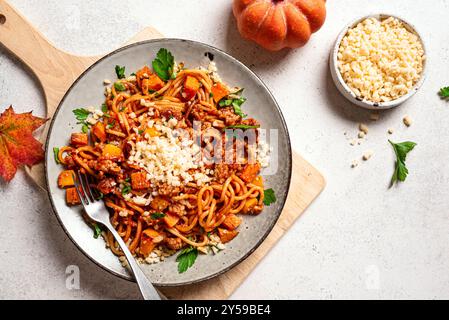 Pumpkin and  Beef Bolognese Spaghetti Pasta with grated parmesan cheese. Homemade spaghetti pumpkin and meat pasta on white concrete background, copy Stock Photo