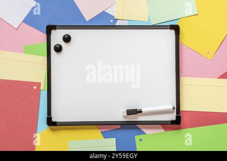 Blank writing board on a background of multicolored paper notes Stock Photo