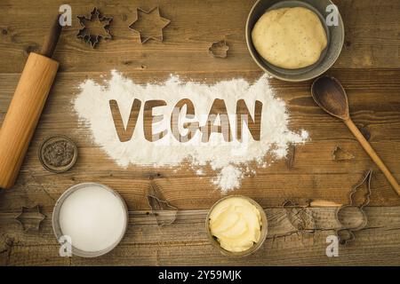 Collection of ingredients and utensils for baking vegan Christmas biscuits with margarine and chia as an egg substitute and the word vegan written in Stock Photo