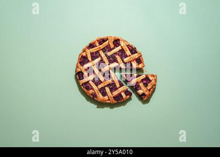 Delicious blueberries cake on a green table above view. Single slice of cake. Home-baked fruitcake. Blueberry pie on a green background flat lay Stock Photo