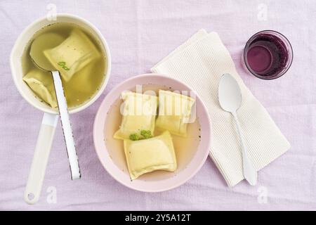 Maultaschen filled pasta squares in broth with water Stock Photo