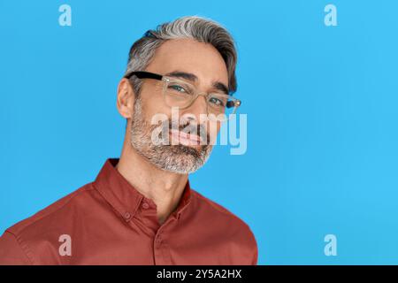 Confident middle aged man wearing glasses isolated on blue background. Stock Photo