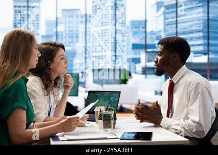 Stock market company HR professional reviewing candidate CV, asking questions about qualifications. Person getting hired by recruiter after proving skills for economic startup job Stock Photo