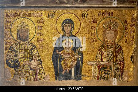 Mosaic of Emperor John II Comnenus, the Virgin Mary, and Empress Irene in Hagia Sophia, Istanbul created in 1118.  This Byzantine masterpiece shows Emperor John II holding a purse, a symbol of generosity, and Empress Irene holding a scroll, signifying wisdom. The Virgin Mary, centered, holds the Christ child. The gold background signifies divinity and the heavenly realm. Stock Photo