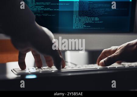 Hands, hacker and typing on computer for programming, data breach or cyber attack at night. Keyboard, closeup or person writing or coding malware Stock Photo