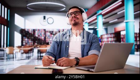 Student Man Thinking At Library While Using Univercity Laptop Stock Photo