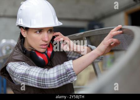 young engineer woman with safety hard hat talking on phone Stock Photo