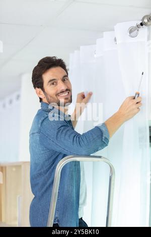 man installing window blinds at home Stock Photo
