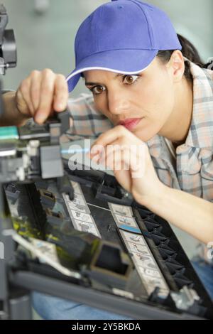 middle aged woman fixing a printer Stock Photo