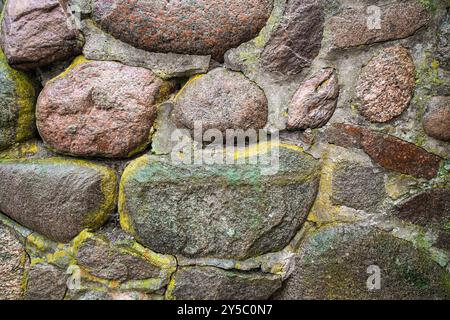 Old stone wall with moss and lichen. Rustic natural background. Stock Photo