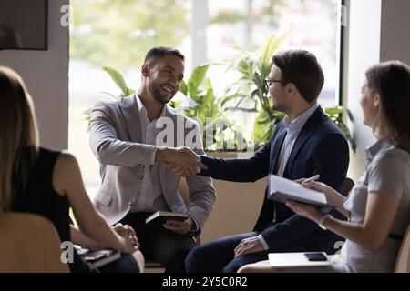 Happy confident handsome businessmen shaking hands on meeting Stock Photo