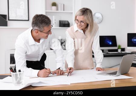 Architects making engineering drawing at wooden table in office Stock Photo