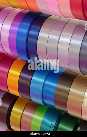 Rolls of multi-coloured decorative ribbons, abstract textile industry background Stock Photo