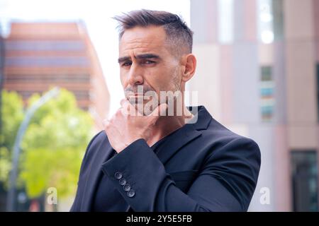 portrait of serious businessman looking at camera outdoors Stock Photo