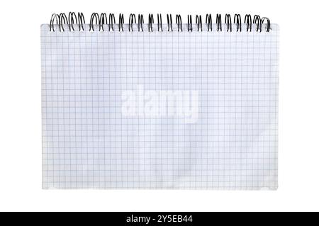 A blank graph paper notebook lying on a table, ready for drawing or calculations in a bright workspace during the daylight hours Stock Photo