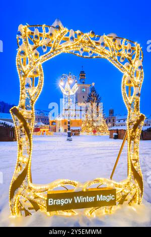 Brasov, Romania. Christmas Market with glowing lights, giant X-Mas Tree, joyful holiday season in Transylvania in white frozen night. Stock Photo