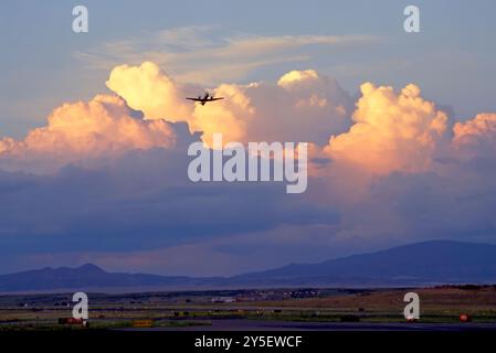 Airliner departs Prescott Arizona airport with monsoon cumulonimbus clouds in the background at sunset over Flagstaff and the Mingus Mountain Stock Photo