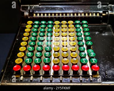 An old fashioned adding machine features a drawer located underneath it Stock Photo