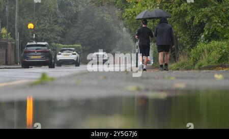 People walking under a umbrella at Boulters Lock, Maidenhead Riverside, Berkshire. Thunderstorms and heavy rain will persist across parts of the UK, as summer officially comes to an end. Thunder and lightning, hail and rain struck various parts of the country on Saturday, including Luton, Bedfordshire, St Albans in Hertfordshire, and Cornwall, with heavy downpours in London, Wales and Birmingham. Picture date: Sunday September 22, 2024. Stock Photo