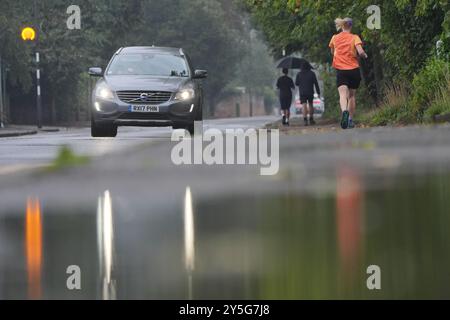 People walking under a umbrella at Boulters Lock, Maidenhead Riverside, Berkshire. Thunderstorms and heavy rain will persist across parts of the UK, as summer officially comes to an end. Thunder and lightning, hail and rain struck various parts of the country on Saturday, including Luton, Bedfordshire, St Albans in Hertfordshire, and Cornwall, with heavy downpours in London, Wales and Birmingham. Picture date: Sunday September 22, 2024. Stock Photo