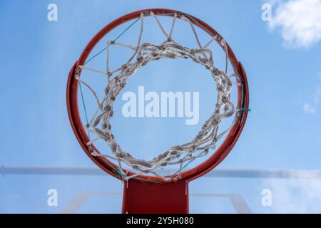 Glass Backboard and Orange Basketball Hoop – Low Angle with Blue Sky Stock Photo