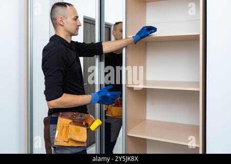 The man is engaged in repair and furniture assemblage Stock Photo