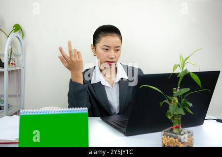 Attractive Asian Chinese Female Young Manager in Formal Dress in Office Gives Gestures Wow Happy with Calendar Mockup Stock Photo
