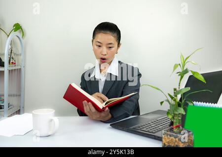 Attractive Asian Chinese Female Young Manager in Formal Dress in Office Gives Gestures Wow Happy with Calendar Mockup Stock Photo
