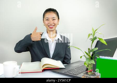 Attractive Asian Chinese Female Young Manager in Formal Dress in Office Gives Gestures Wow Happy with Calendar Mockup Stock Photo
