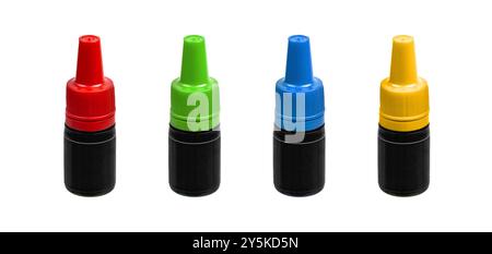 Four small black bottles with colorful caps arranged in a row. Red, green, blue, and yellow on a white background. Ideal for product display, design p Stock Photo
