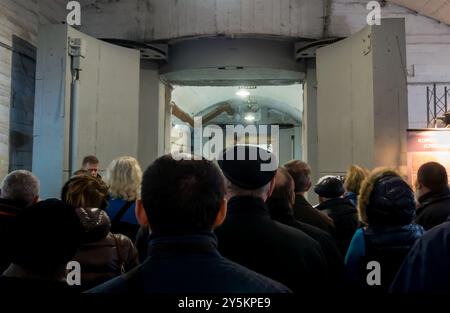 Balaklava, Crimea - November 14, 2015: People stand at the pressure gate of an underground bomb shelter Stock Photo