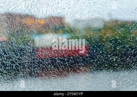 A shattered glass texture beautifully blurs the vibrant colors of the garden beyond, capturing a moment of fractured reflection Stock Photo