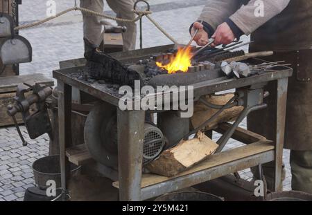 A blacksmith is a metalsmith who creates objects from wrought iron or steel by forging the metal, using tools to hammer, bend, and cut- shot in 2014 Stock Photo