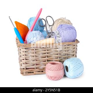 Colorful yarns, crochet hooks, scissors and measuring tape in wicker basket isolated on white Stock Photo