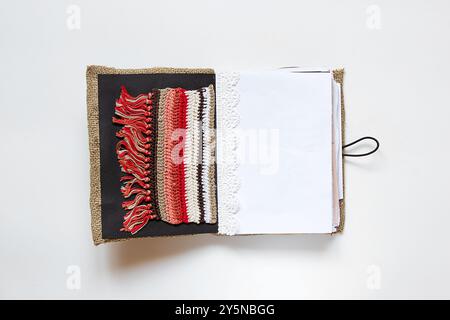 Open homemade notebook made of fabric and lace and different pages on white background, handmade notebook Stock Photo
